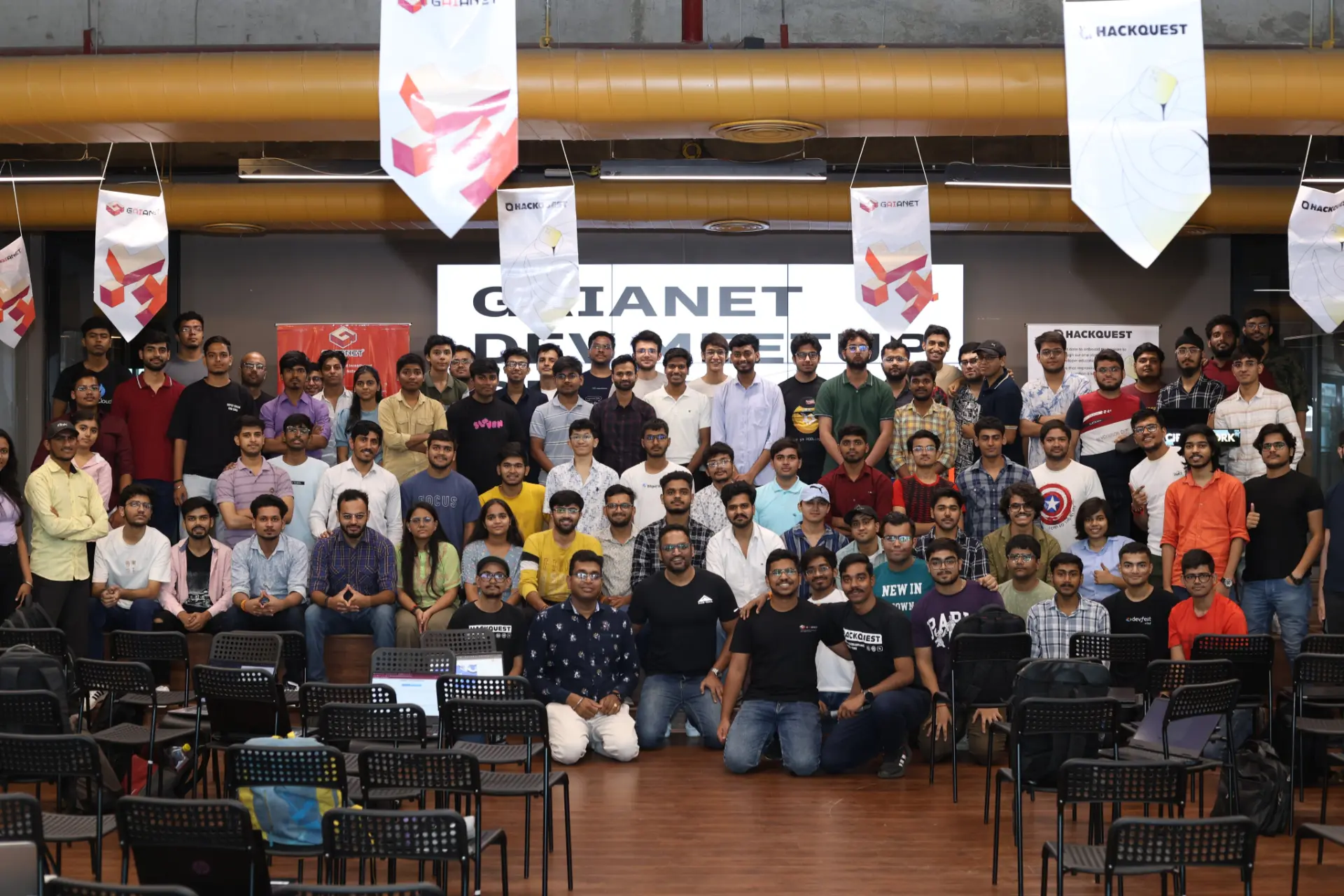 Developer meetup attendees gathered in front of the event stage for a group photograph